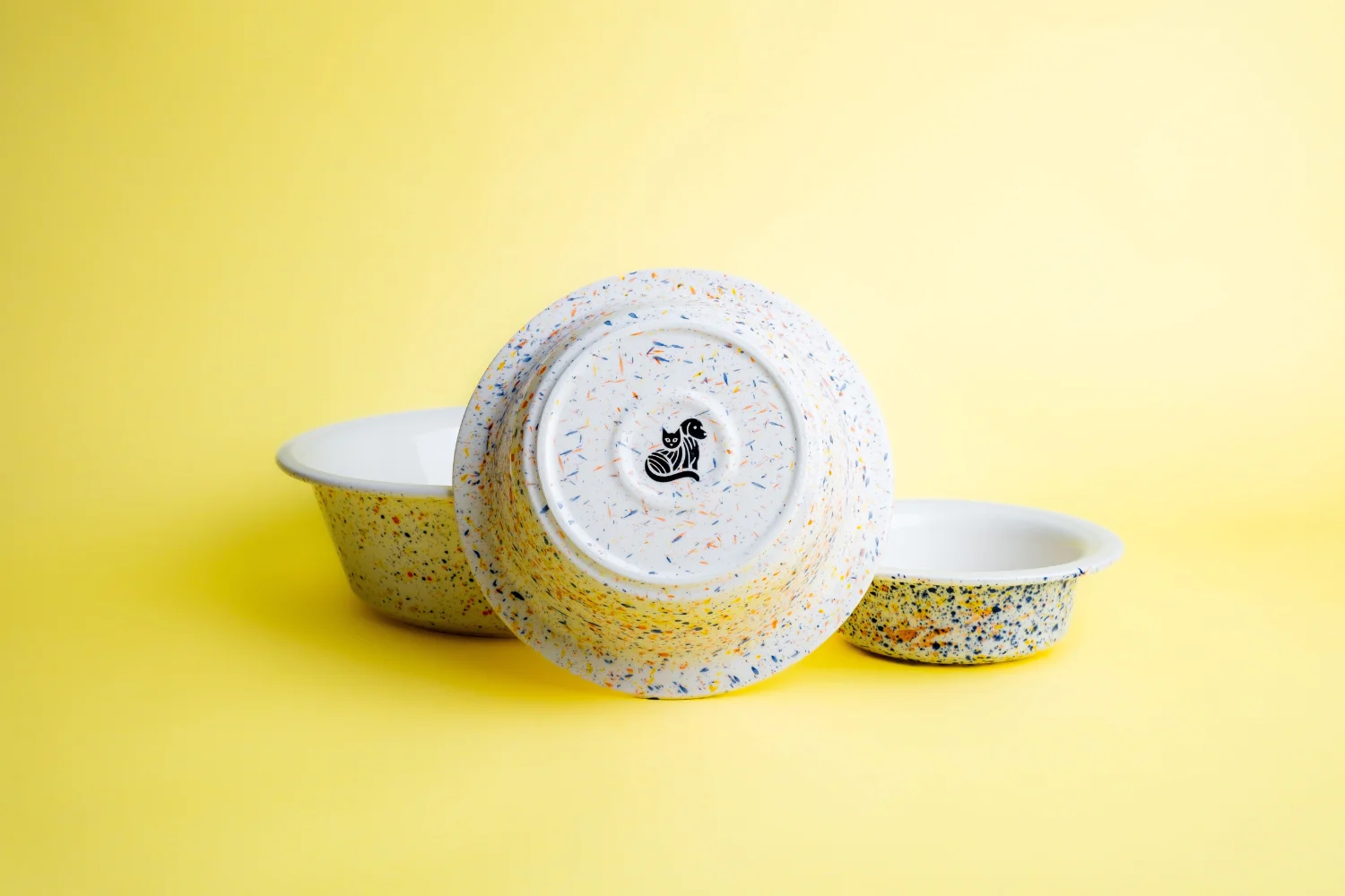 TierischEdel-Keramiknapf-im-Sprenkelmuster-gefuellt-mit-Hundesnacks-daneben-umgedrehte-Schale-mit-Logo